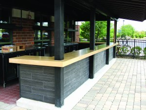 This precast outdoor bar countertop by Fishstone Studio was designed in five pieces to accommodate the shape and existing support poles.