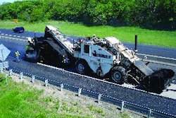 A Shuttle Buggy feeds asphalt into the Roadtec SP-200 spray paver, which is paving the driving lane on Interstate 35 in Kansas.