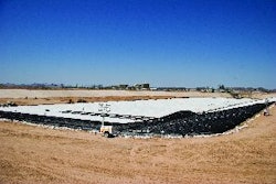 After a grading contractor spread and compacted the treated material on the sloped side walls, the entire pond was covered with a two-layer liner to seal it from any leakage.