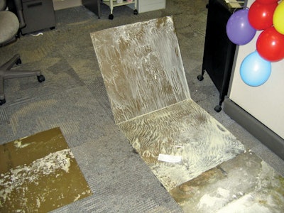 Water vapor that traveled through the concrete slab reached dew point and re-emulsified the water-based glue that once secured these carpet tiles to the concrete substrate.