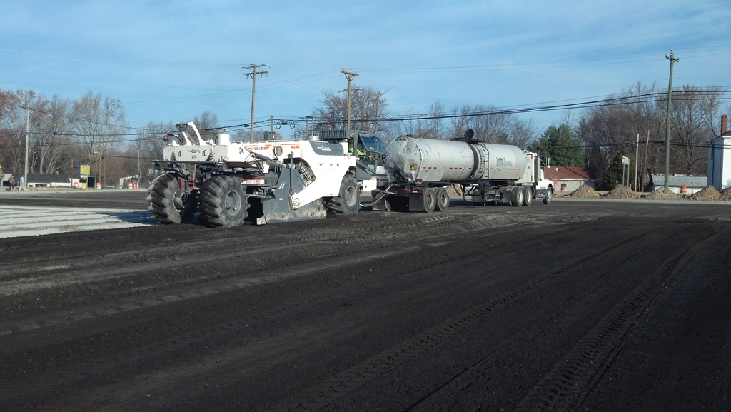 A reclaimer and emulsion tanker introduce emulsion to the RAP, placed on top of a cement-treated subgrade.