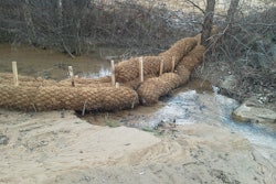 Erosion control products, including coir logs and jute mesh matting, slow erosion in the existing stream. Silt that used to end up in Lake Norman is visible in the foreground of the photo.