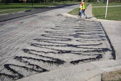 Improper application of tack coats, like this tack that was applied by hand using a pour bucket, eliminates any benefits that can result from using tack coats to improve paving.