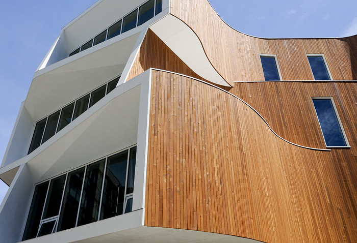 The building features distinct curves and apertures that make it standout visually as well as allow sunlight and shade to be optimized for the lighting and temperature, saving energy and enhancing comfort levels for occupants.