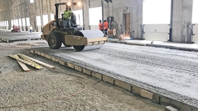 Base course being compacted with vibratory roller.
