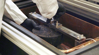 Researcher prepares asphalt specimen for the DCT (Disc Shaped Compact Tension) test.