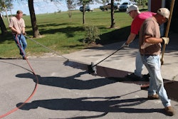 Use a brush and squeegee to spread the sealcoat out on the pavement