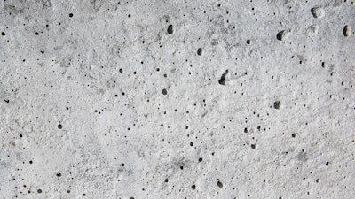 Coating voids and pores in a concrete floor.