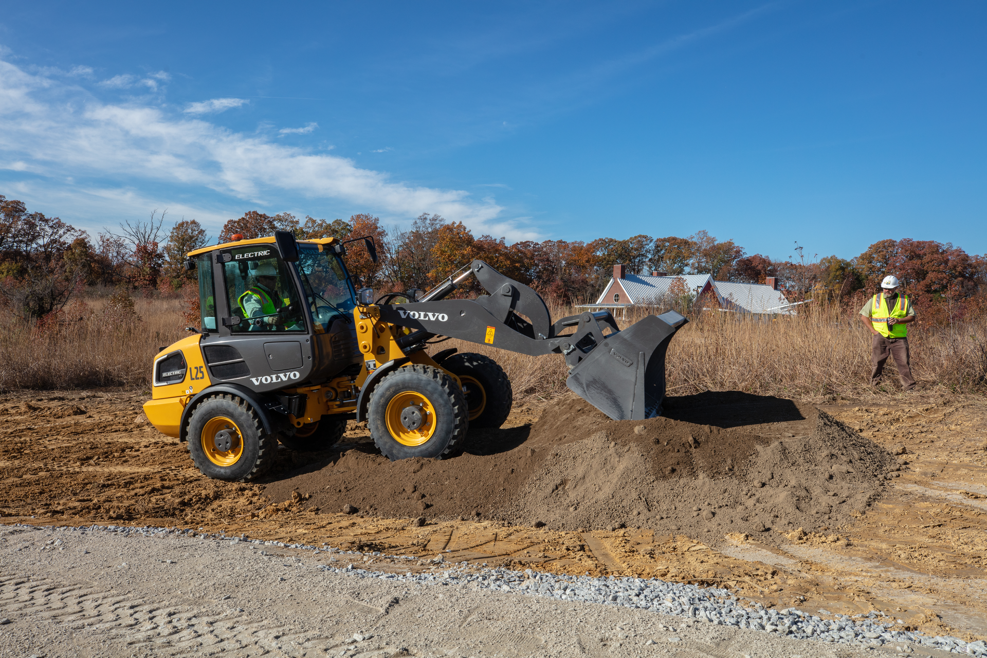 The L25 Electric compact wheel loader is being used to haul and lay down gravel for a wheelchair-accessible half-mile trail around a pond and to clear brush.