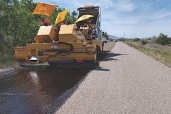 Crews place aggregate over oil emulsion