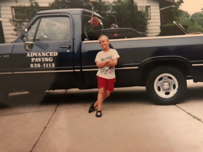 A young David Martin leaning up against his dad's work truck.