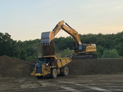 An excavator loads a truck during the demo