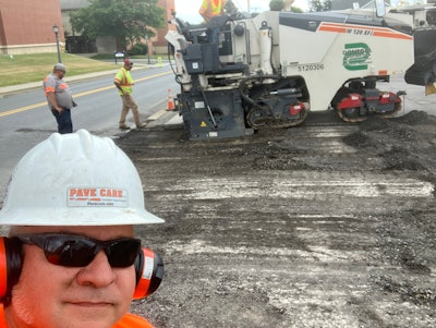 Pave Care Founder Rick Dillaman (white hard hat) and Pave Care employee Joe Dillaman (background) oversee a sub-contracted milling crew for a paving project at Clarion University.