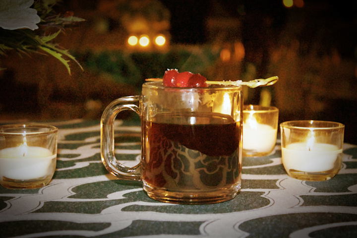 Chicago catering firm Food for Thought offers a mulled spiced wine with cabernet sauvignon, apple cider, citrus, and spices. The drink is garnished with a cranberry skewer.