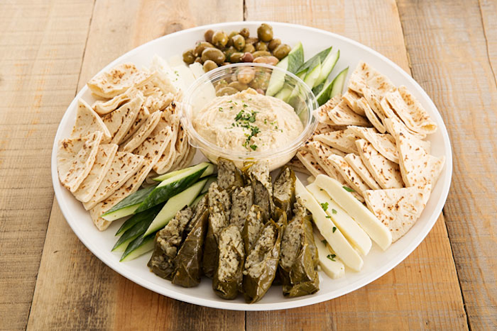 House-made hummus, handmade dolmas, cucumbers, marinated olives, halloumi cheese, and pita triangles, by Bi-Rite Catering in San Francisco