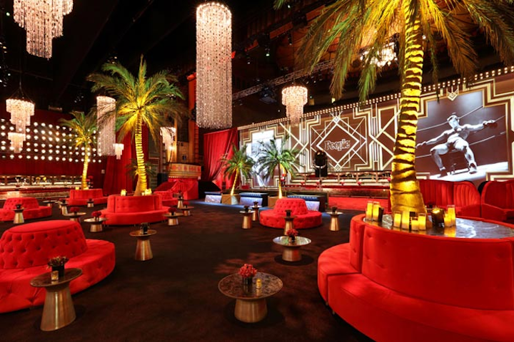 Candles and floral arrangements topped golden tables and rich red tufted sofas provided seating. Waitstaff in white tux jackets added to the glam vibe.