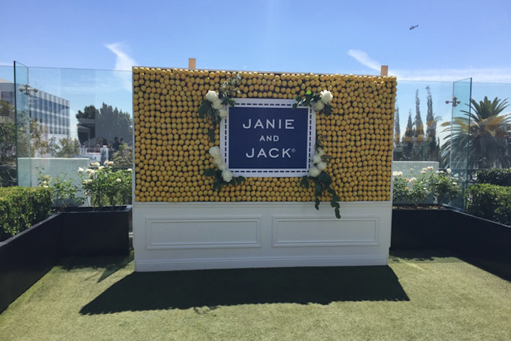 Preppy kids' retailer Janie and Jack celebrated the launch of its summer collection on June 18 at the London West Hollywood hotel in Los Angeles. In keeping with the moulding-trimmed look of the pop-up shop, a press wall appeared more like a piece of furniture than a temporary photo backdrop. Decorated with lemons for an eye-catching yellow look, the wall also featured logo signage in the brand's signature blue color, as well as white florals and trailing greenery.