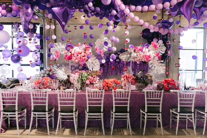 For the 1980s, Winner Circle Events' Melody Ponce was inspired by the cover of Prince's 1984 album Purple Rain. 'The 80s was known as the 'decade that made us,' she explained. 'The people, the changes, and the inventions paved the way for the future. It was 10 years of glamour, ruthless ambition, and explosive technology, and produced the historic changes and global events that make us who we are today.' Bright purple balloons from Balloonzilla, along with flowers from Los Angeles Floral Couture, created a cloud-like shape that was 'raining' over the table and ceremony backdrop.