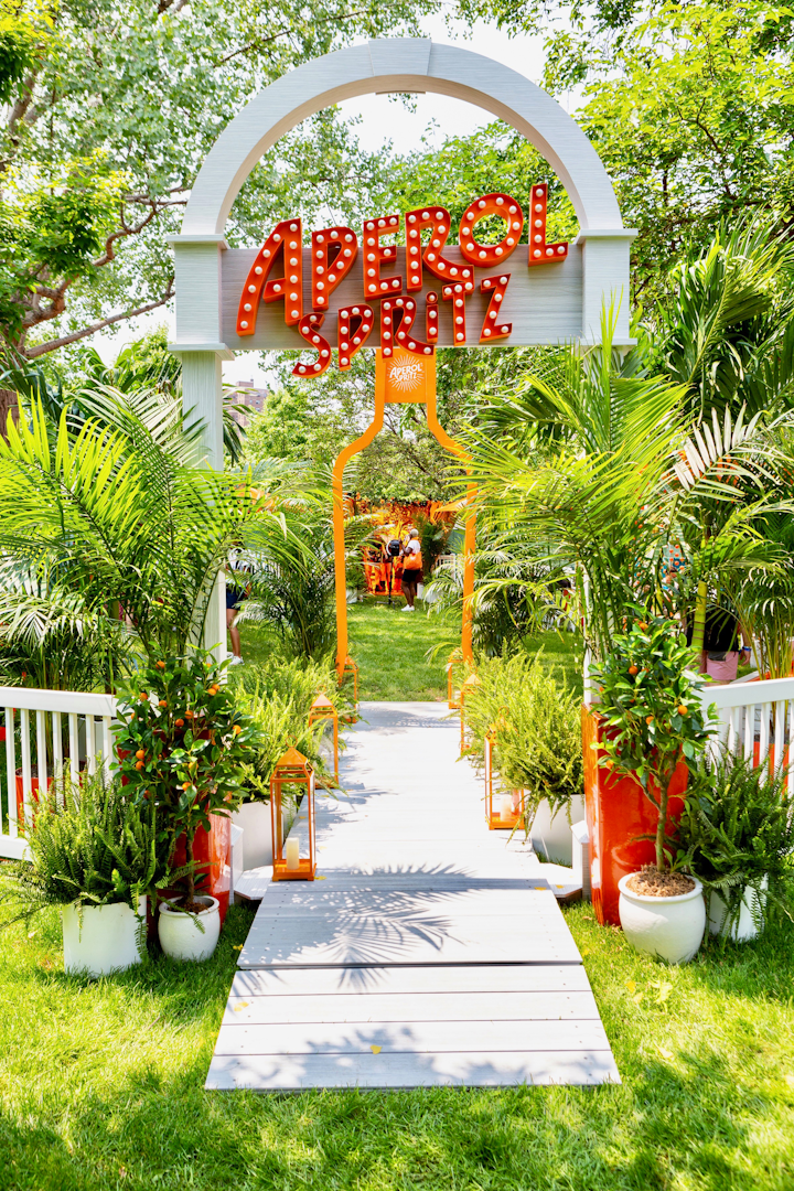 The Italian aperitif, now a summer cocktail staple, celebrated its 100th anniversary with a garden oasis, located in the 21-and-over section of the festival grounds. The activation, which was produced by Swell, welcomed guests with marquee signage and an oversize silhouette of the brand’s orange bottle.