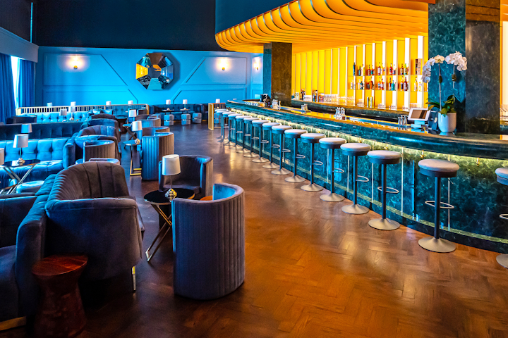 To recreate Lyaness cocktail bar in London, the brand worked with fabrication studio 11th Street Workshop. Decor at the cocktail bar includes blue plush furniture, a green granite bar, and a geometric mirror. See more: Q&A: Why Is Mastercard Opening Restaurants in New York?
