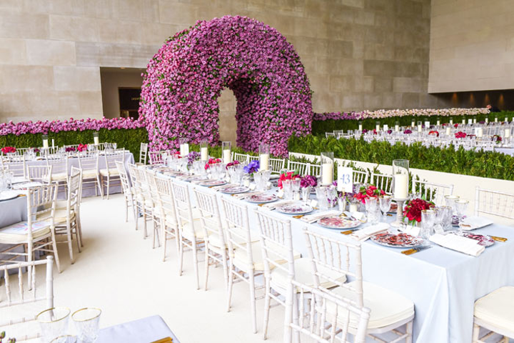 For dinner, guests entered the Temple of Dendur through an arched doorway in a 70-by-20-by-10-foot wall made of 300,000 roses. Because no props could be hung from the ceiling in the room, decor was largely grounded to the floor. To maintain longevity, the roses were conditioned at Avila's Brooklyn studio for three days, then cut on Sunday morning and set in an environment where moisture was closely regulated. The wall was installed later that day. The roses on the wall ranged from white to lavender to red, and extended from north to south across the entire width of the room. In total, 250 people spent 200 hours setting up, which amounted to 50,000 hours total. See more: See How Tech and Fashion Mixed at the Met Gala