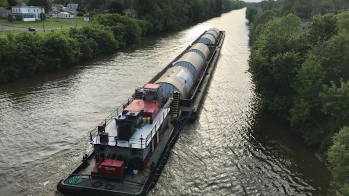 In this undated photo, a barge carrying Chinese-made beer fermentation tanks floats down the Erie Canal in Clyde, N.Y., toward the Genesee Brewery in Rochester, N.Y. Some politicians are irritated that the Rochester brewery, which receives state economic development funding, bought beer fermentation tanks from China that could have been produced in New York. (Michael Riviello via AP)