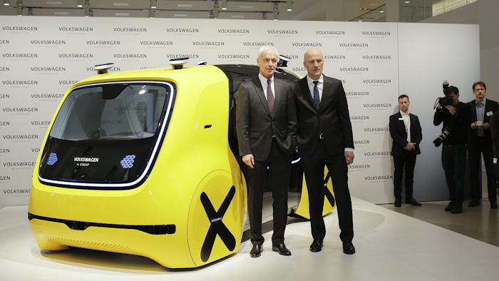 VW group CEO Matthias Mueller, left, and CFO Frank Witter, right, pose in front of a self driving concept car prior to the annual media conference of the Volkswagen group, in Berlin, Germany, Tuesday, March 13, 2018. Image credit: AP Photo/Markus Schreiber