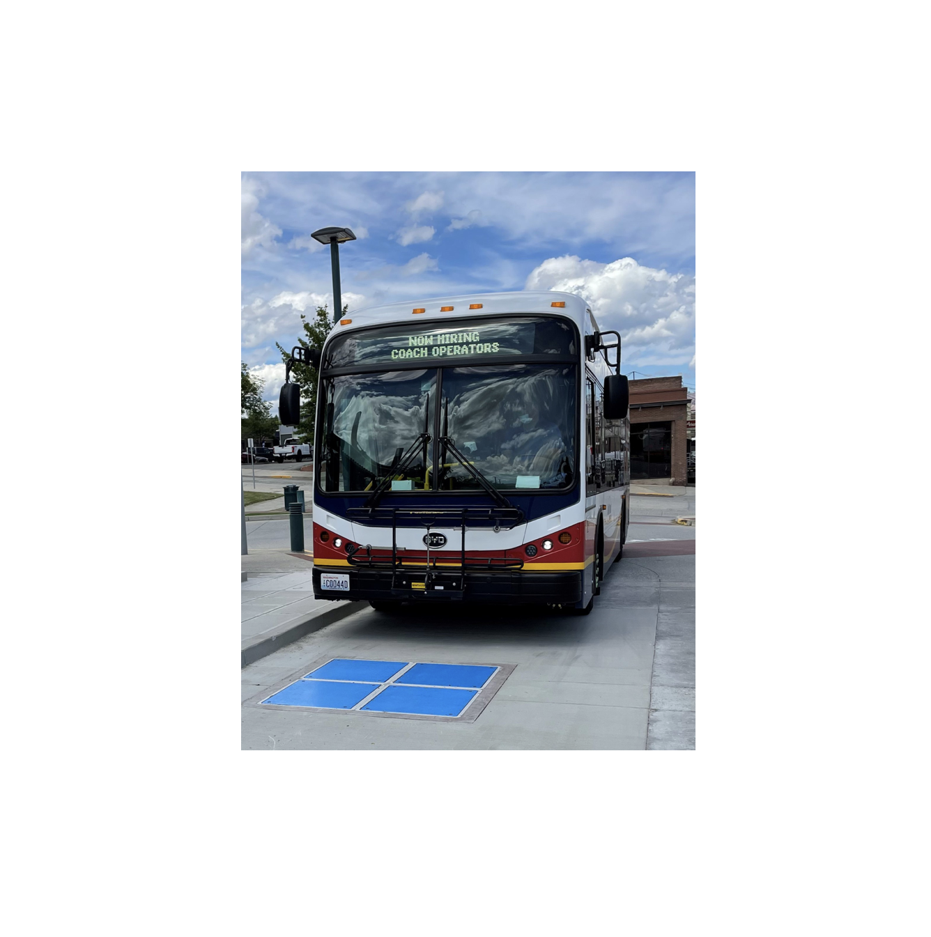Municipal bus approaching a wireless inductive charging pad.