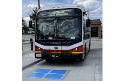 Municipal bus approaching a wireless inductive charging pad.