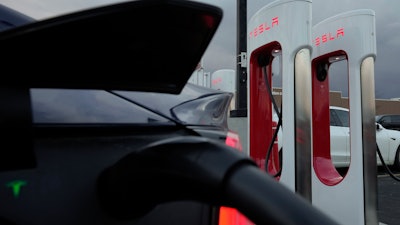 A vehicle charges at a Tesla Supercharger station in Detroit, Nov. 16, 2022.