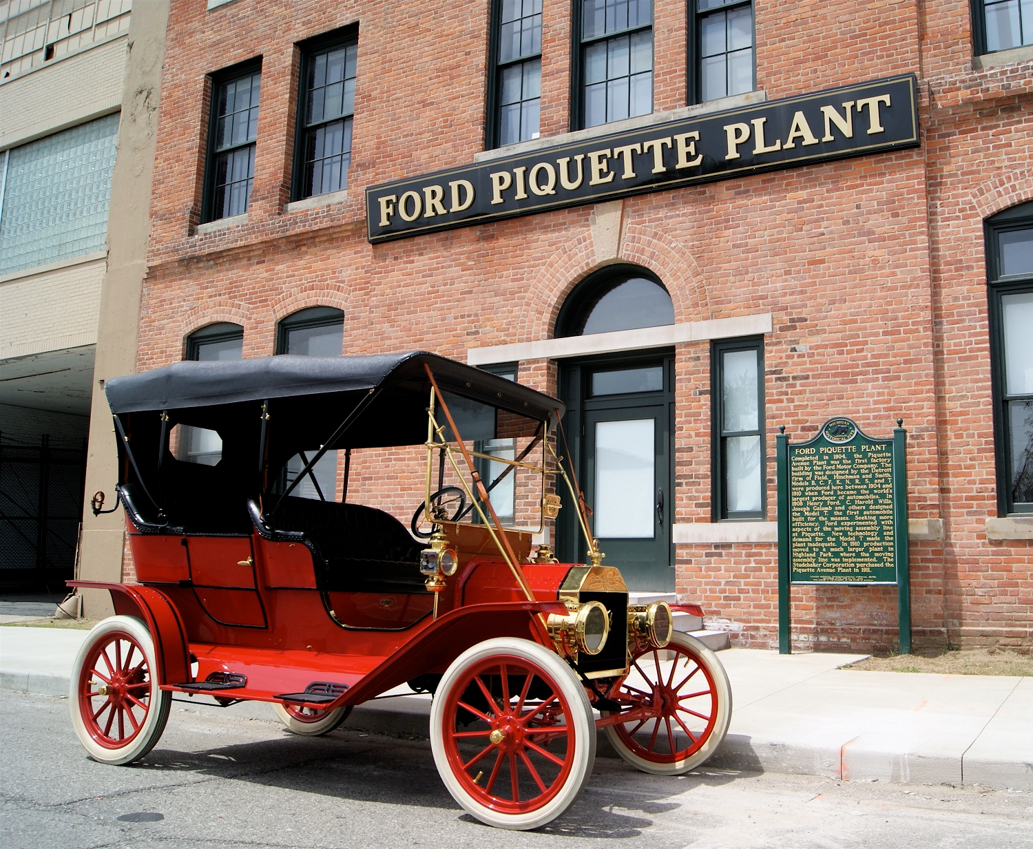 A 1909 Model T in front of the factory where it was made, the Ford Piquette Avenue Plant.