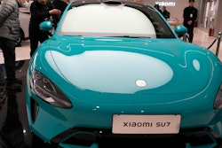 Visitors to the Xiaomi Automobile flagship store look at the Xiaomi SU7 electric car on display in Beijing, Tuesday, March 26, 2024.