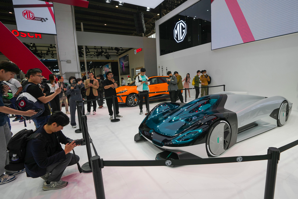 Visitors take photos of a MG concept car during an opening of China Auto Show in Beijing, China, Thursday, April 25, 2024.