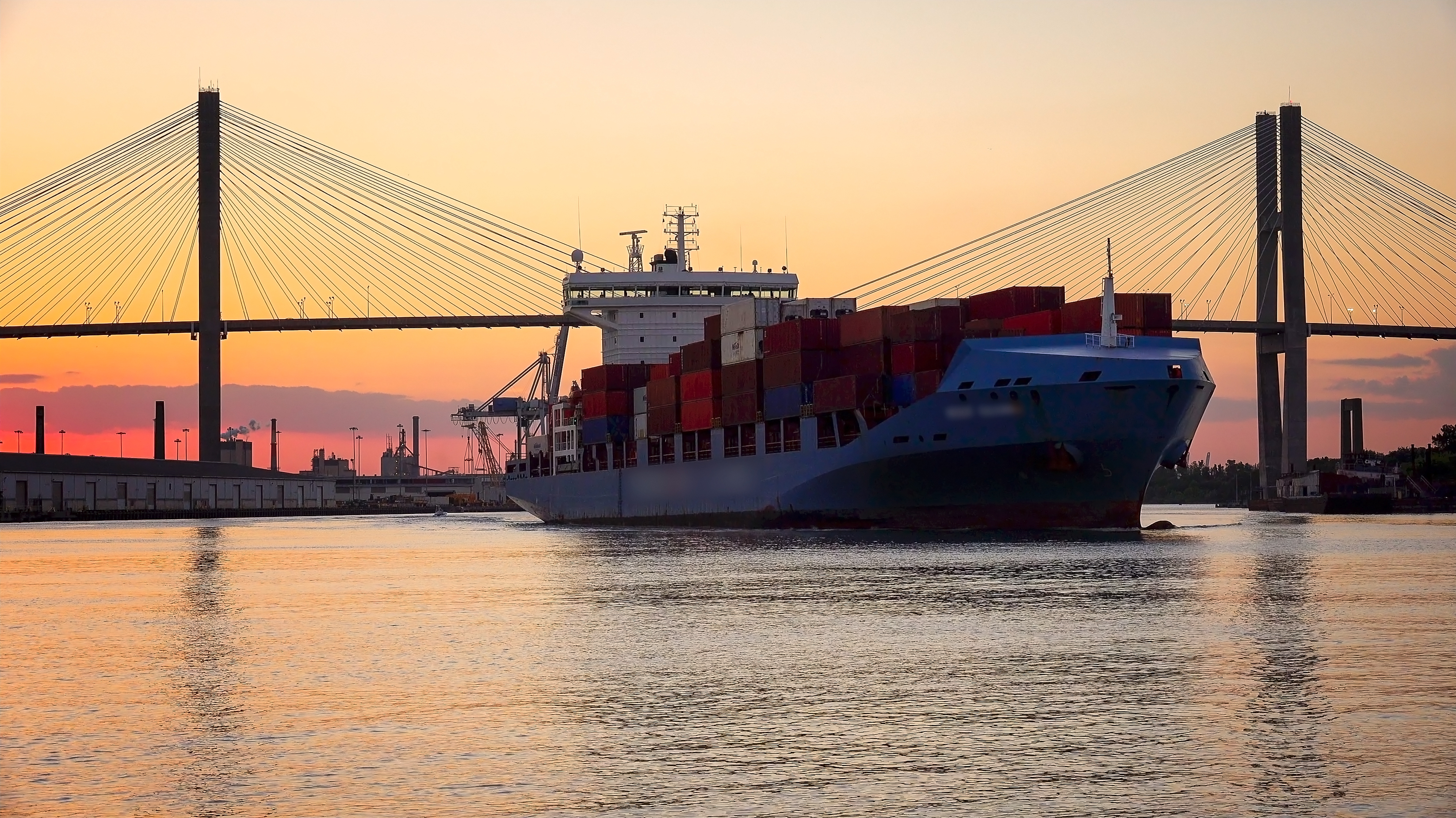 A commercial cargo ship as it leaves the Port of Savannah in Georgia at sunset.