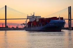 A commercial cargo ship as it leaves the Port of Savannah in Georgia at sunset.