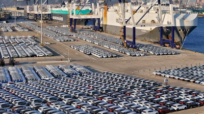 New cars for export wait for transportation on a vehicles carrier vessel at a dockyard in Yantai in east China's Shandong province.