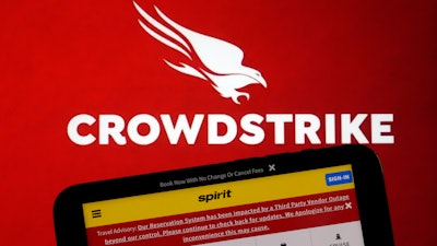 The logo for CrowdStrike and a Spirit Airlines webpage are shown on a computer screen and mobile phone screen, in New York.
