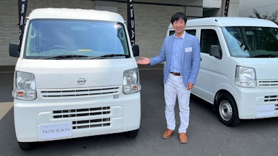Susumu Miura, a Nissan Research Center manager, shows a Nissan car that is coated with the special “cool paint,” under testing at Tokyo’s Haneda airport.