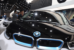 A worker cleans an electric vehicle at the BMW booth during the Auto Shanghai 2019 show in Shanghai on April 17, 2019.
