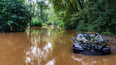 A partially submerged vehicle sits in flood water from after Hurricane Helene passed the area, Friday, Sept 27, 2024, in Atlanta.