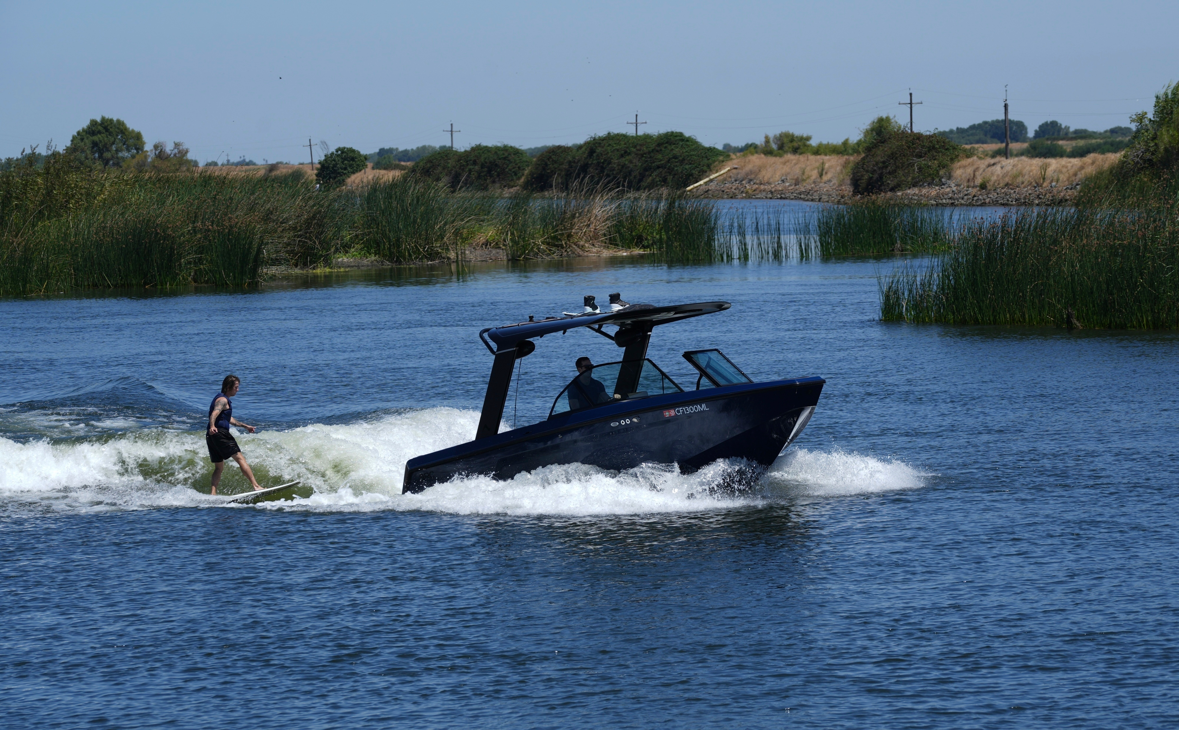 Grant Jeide wake surfs behind an electric sports boat made by California-based Arc Boats on the Sacramento-San Joaquin Delta near Bethel Island, Calif. on Wednesday, July 31, 2024.