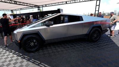 Visitors look over a 2024 Cybertruck in the Tesla display at the Electrify Expo, July 14, 2024, in north Denver.