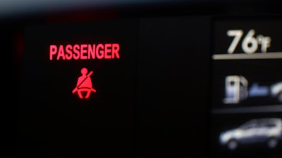 A seat belt warning sign for the right front passenger seat is displayed in a vehicle on Monday, Aug. 21, 2023.