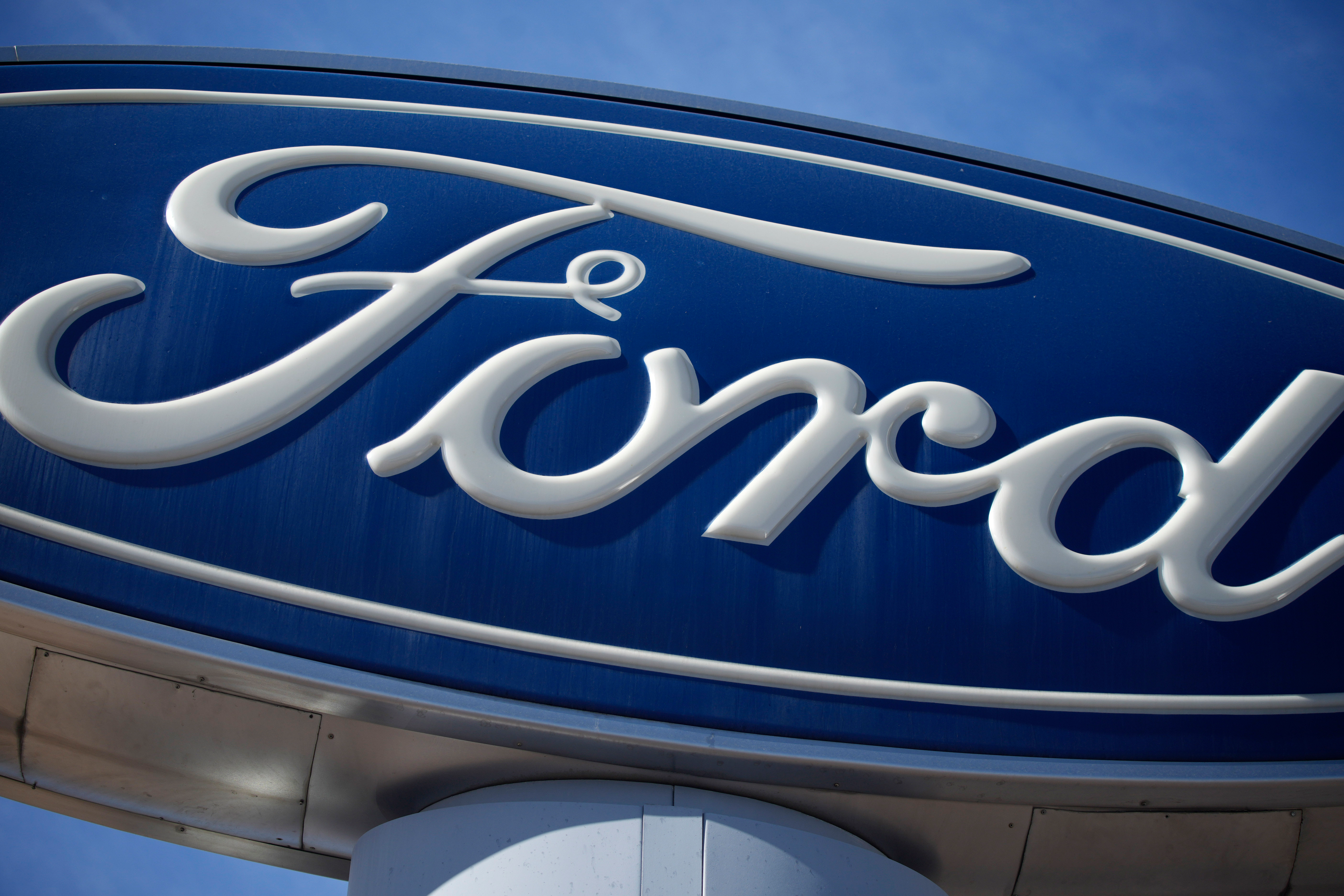 The Ford company logo is seen, Oct. 24, 2021, on a sign at a Ford dealership in southeast Denver.
