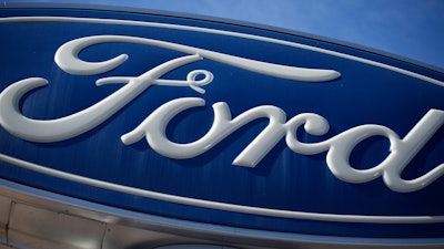 The Ford company logo is seen, Oct. 24, 2021, on a sign at a Ford dealership in southeast Denver.