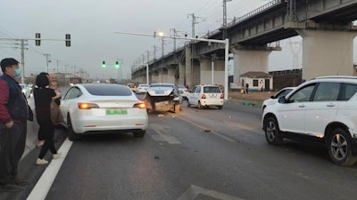 This photo provided by Zhang Yazhou shows her damaged Tesla Model 3, left, which her father was driving when it hit two other cars before crashing to a halt against a concrete barrier in Anyang, a city in central China’s Henan province, on Feb. 21, 2021. Zhang was in the passenger seat. Her mother and her one-year-old niece were at the back.