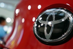 People walk by the logo of Toyota at a show room in Tokyo, Aug. 2, 2019.