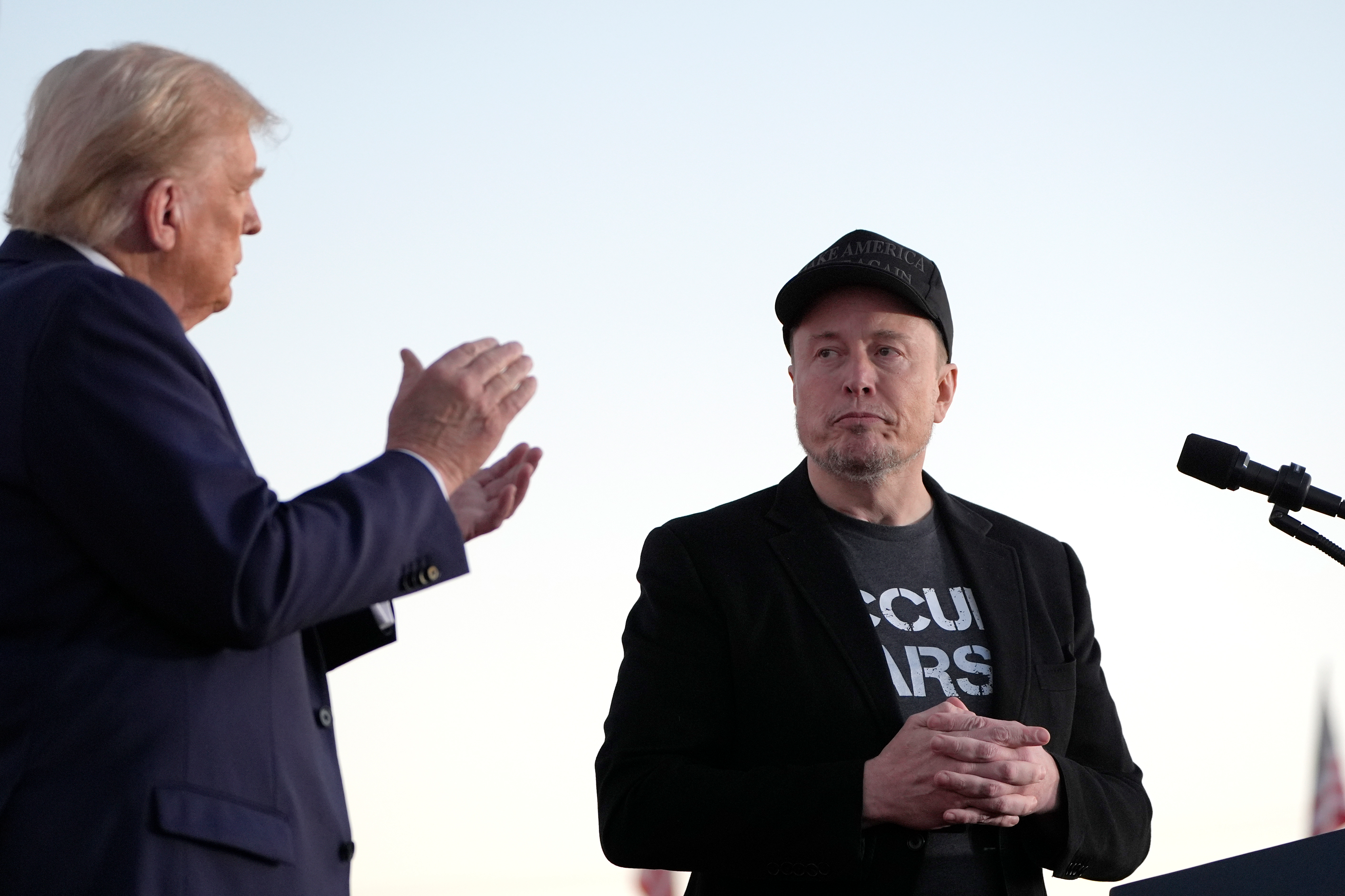 Republican presidential nominee former President Donald Trump, left, claps as Tesla and SpaceX CEO Elon Musk prepares to depart after speaking at a campaign event at the Butler Farm Show, on Oct. 5, 2024, in Butler, Pa.
