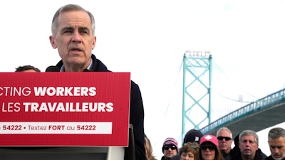 Unifor auto workers stand behind Liberal Leader Mark Carney as he speaks during a campaign stop at the Ambassador Bridge in Windsor, Ont., on Wednesday, March 26, 2025.