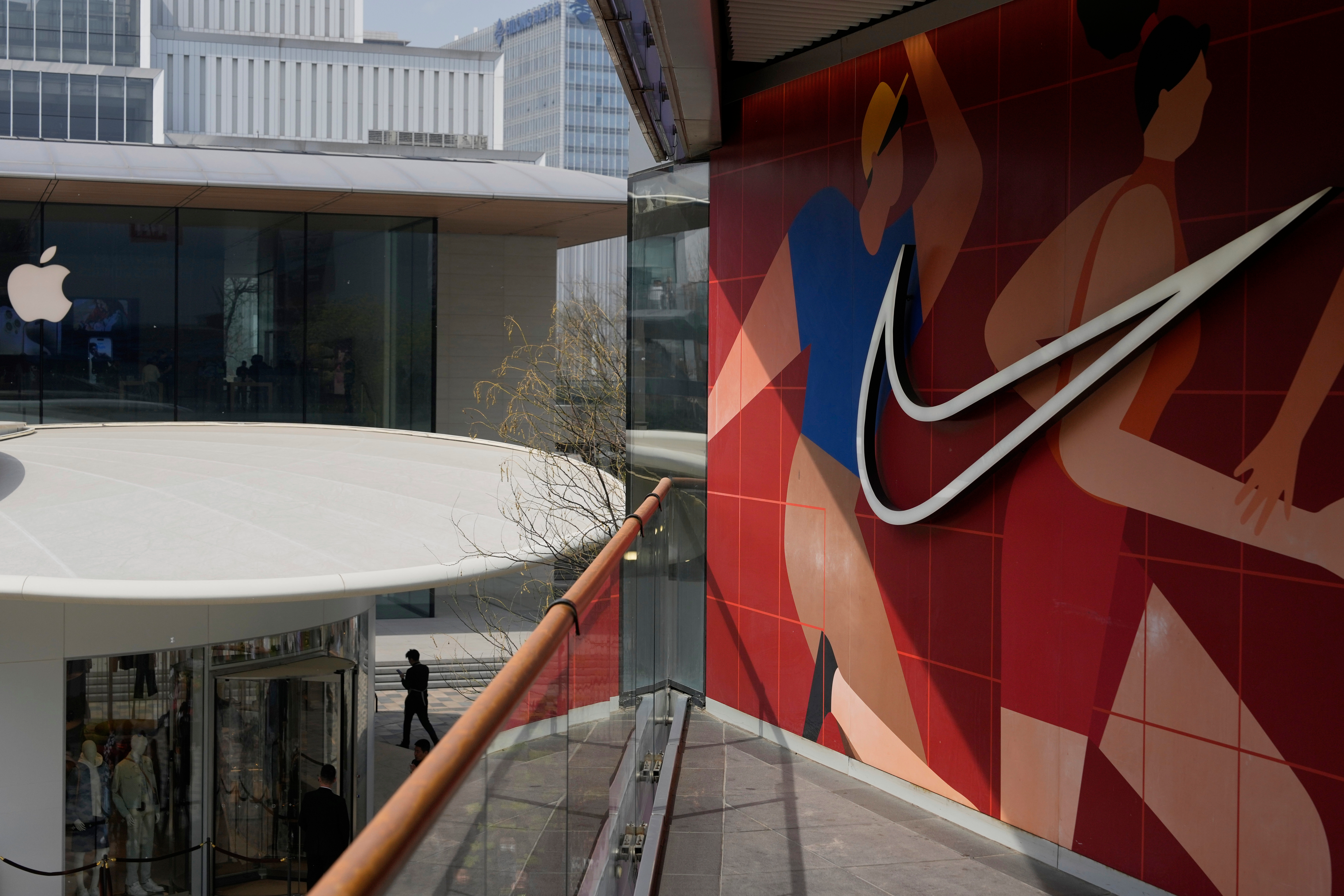 A man walks past Apple and Nike stores in Beijing, China, Friday, April 4, 2025.